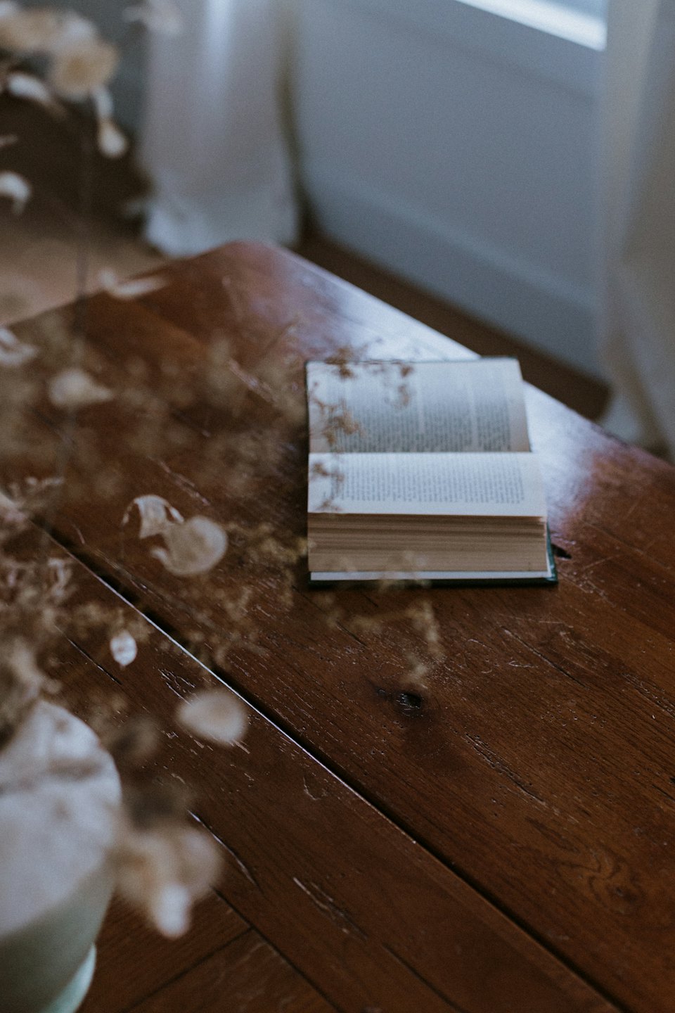 Un libro abierto descansa sobre una mesa de madera rústica.