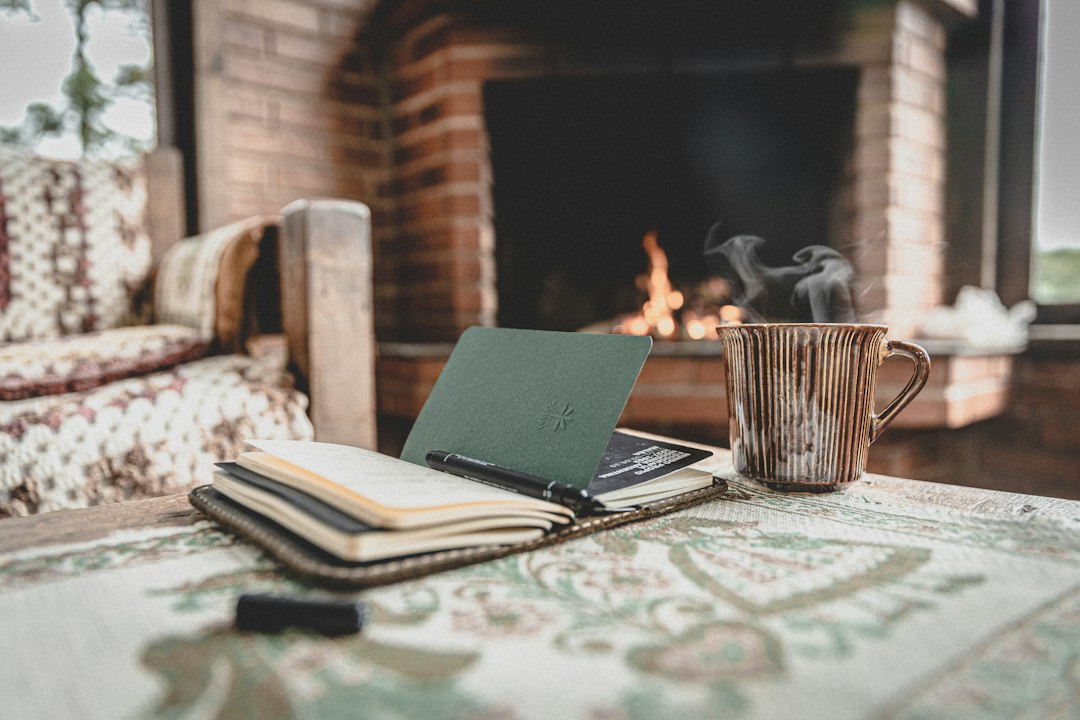 Open journal and steaming mug on a patterned tablecloth.